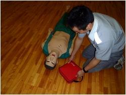 心肺蘇生法を実施中、AEDが到着したら、すぐに準備を行っている写真